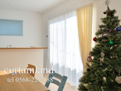 ライトブルーのロールスクリーンと木製チェア